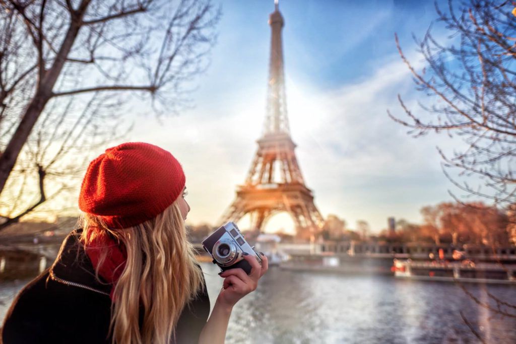 Une visiteuse photographie la tour Eiffel depuis les quais